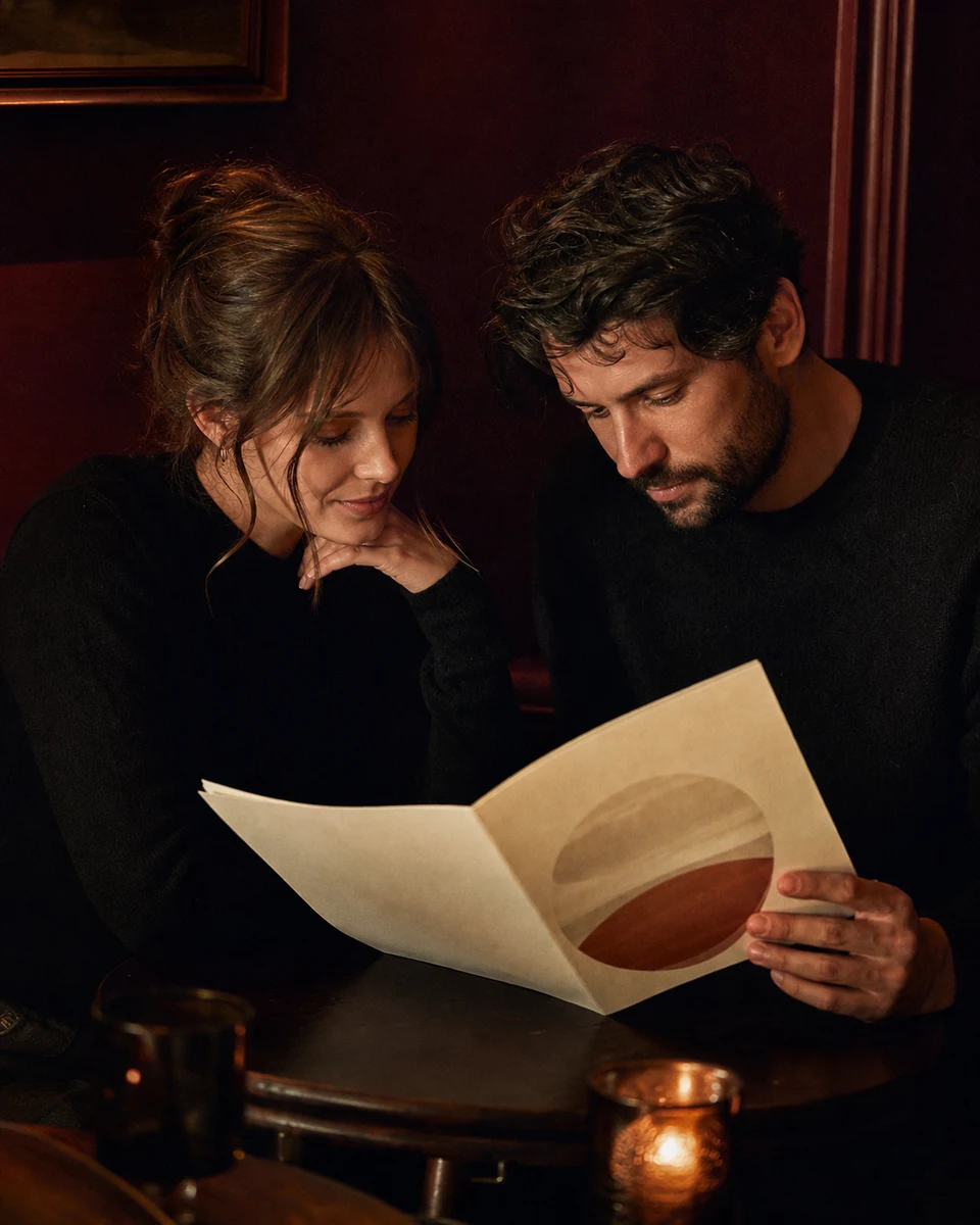 A person reading a printed compatibility reading, absorbed in the page.